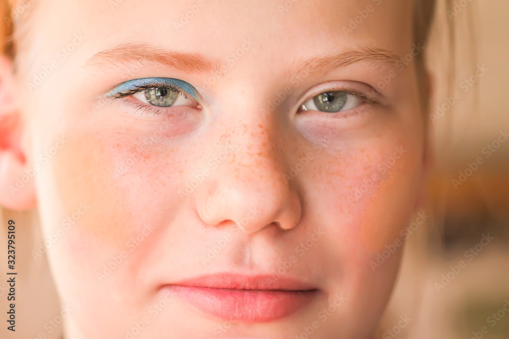 Young attractive teenager girl's face view with eyeshadows and lipstick on lips