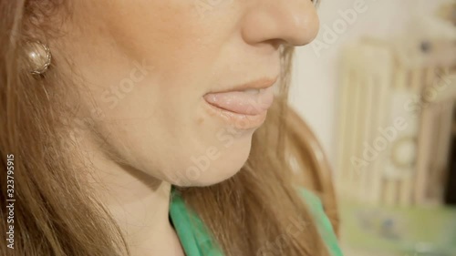 An attractive woman biting her lips, a clear nonverbal sign of attraction and interest in someone. Detail shot.