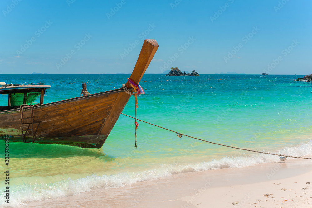 Traditional Thai longtail boat moored on exotic beach.