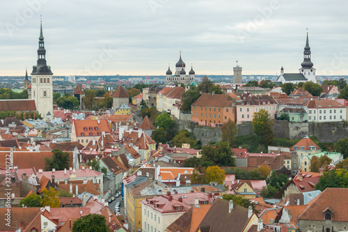 Historic skyline of Tallinn, medieval buildings, towers, castle in the old town seen from the tower of St. Olaf's church. Sightseeing on a cloudy autumn day. Top travel destination Estonia, Europe.