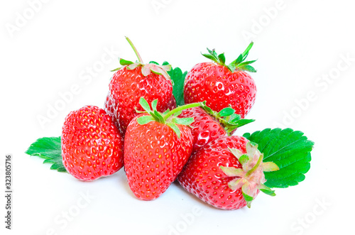 Heap of strawberries with half cut and leaves isolated on a white