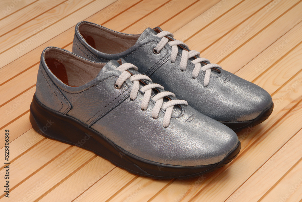 leather blue footwear, shine sneakers are on wooden background