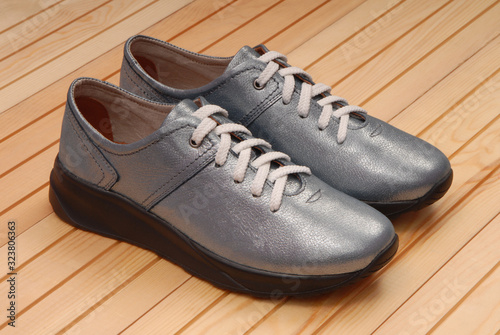 leather blue footwear, shine sneakers are on wooden background