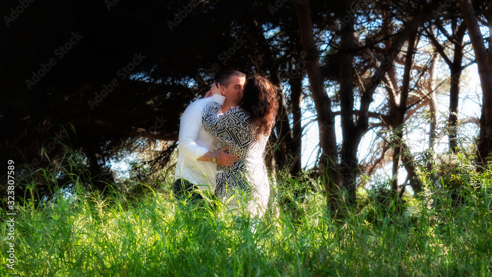 Joven pareja de novios besándose apasionadamente en el bosque Joven pareja de novios besándose apasionadamente en el bosque