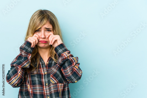 Young blonde caucasian woman whining and crying disconsolately.