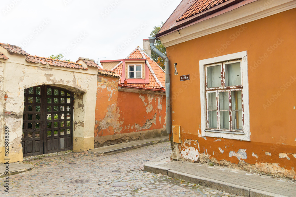 Orange houses on intersection of Toom-Kooli and Kiriku streets in Tallinn. The area near Toomkirik in old town on Toompea hill is interesting for tourists in Estonia. Road is paved with cobblestones 