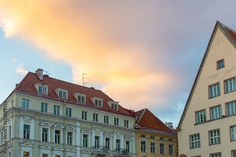 Bright colourful sunset sky over the elaborate merchant houses on Raekoja plats in the old town of Tallinn, Estonia, Europe. The Town hall square is a venue for open-air concerts, fairs, markets.