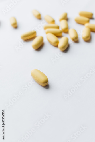 Scatterded yellow pills on white background 