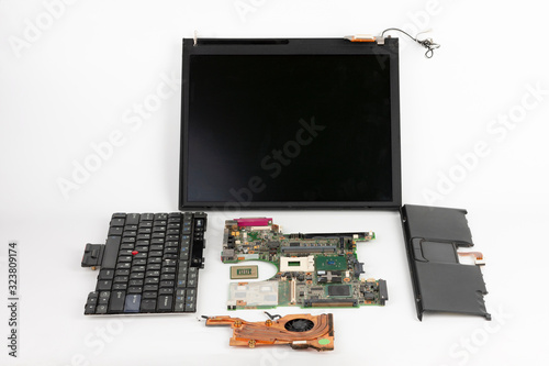 Disassembled laptop, basic components of notebook, screen,  keyboard, processor,  motherboard, touchpad , CPU fan.