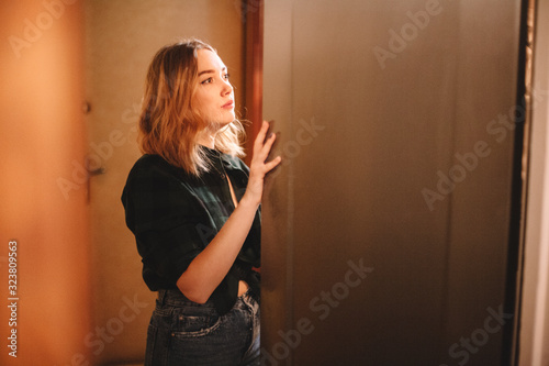 Φωτογραφία Young hungry woman looking in open refrigerator at home