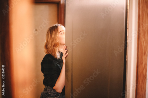 Young hungry woman looking in open fridge at home