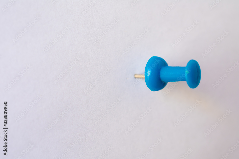 blue pin attached on a white, empty paper blue pin attached on a white, empty paper