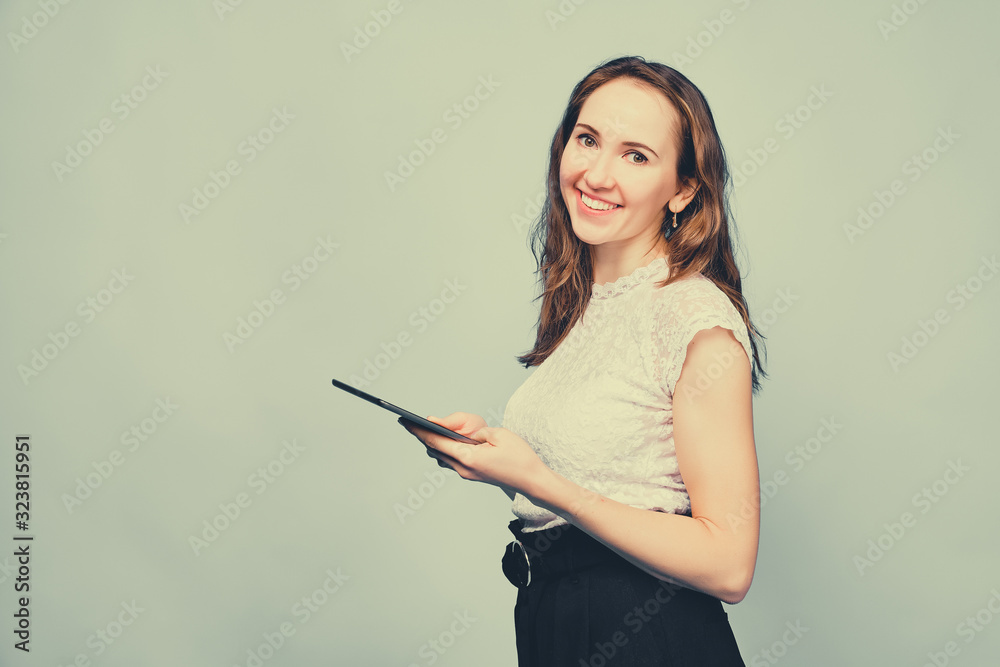 Brunette girl in casual clothes with a tablet offers promotions for the sale of products. Toned.