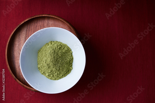 A bowl of the ayurvedic powder Sidr (Zizyphus jujuba) on a deep red background