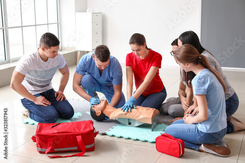 Instructors demonstrating CPR on mannequin at first aid training course