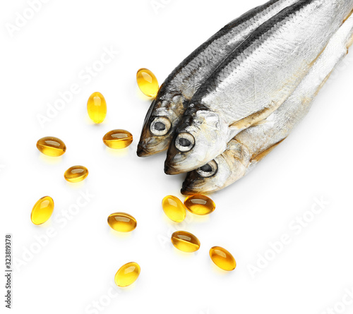 Fish with oil pills on white background