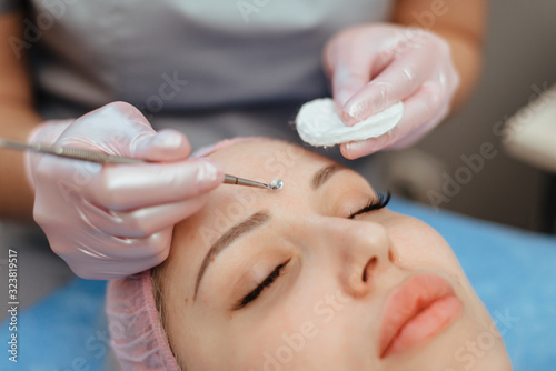mechanical cleaning of the face around the nose patient spa salon using an extractor © Sergey
