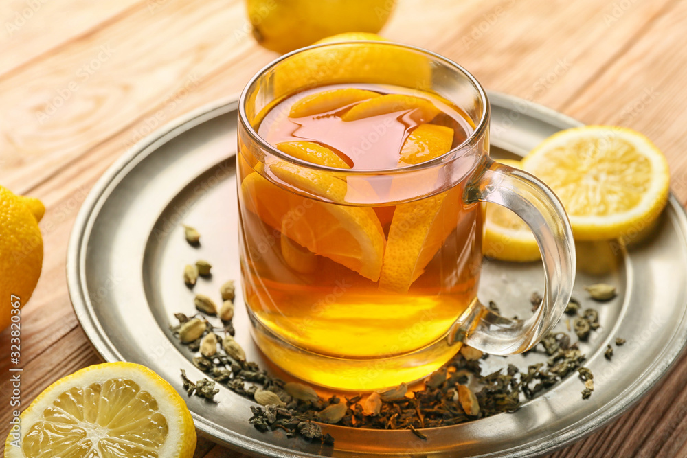 Cup of hot tea with lemon and cardamom on table Cup of hot tea with lemon and cardamom on table