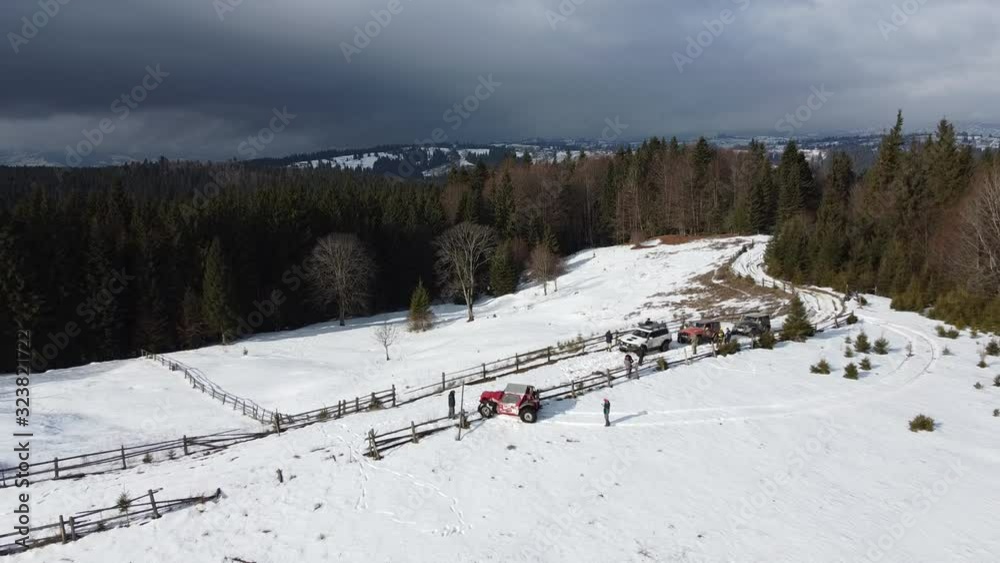 A group of SUVs stopped in a snowy meadow on top of a mountain A group of SUVs stopped in a snowy meadow on top of a mountain