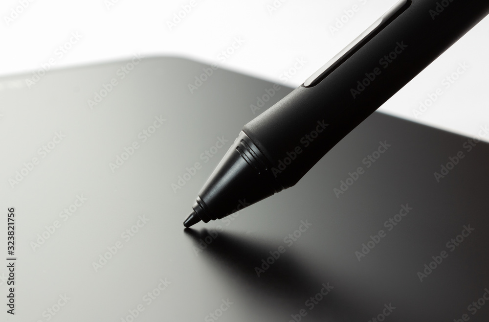 Pen on graphic tablet. Side view on white background. Pen on graphic tablet. Side view on white background.