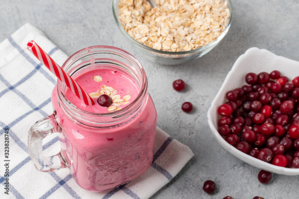 Freshly homemade smoothie with cranberries, oatmeal and yogurt in a mug jar on a gray table. Healthy eating concept