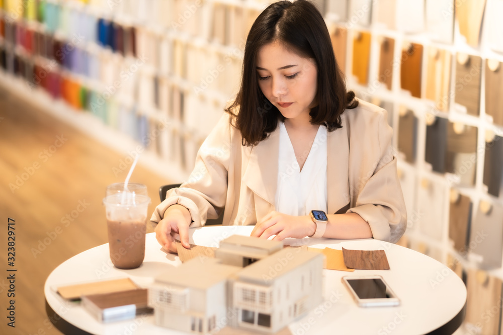 Architect or interior designer working with material sample board in showroom. Business of Real estate, home decoration .Creative people workplace. young designer woman working . Architect or interior designer working with material sample board in showroom. Business of Real estate, home decoration .Creative people workplace. young designer woman working .