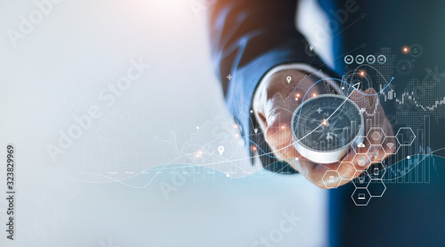 Fotografia Businessman holding a navigation compass in hand and define marketing direction and analysis growth sale data with search customer global network, Abstract business