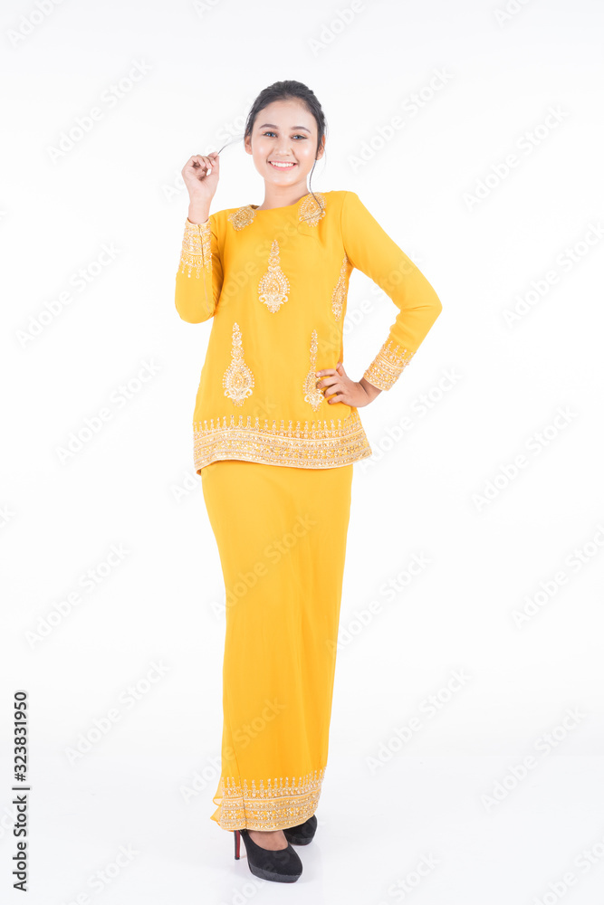 Obraz premium Beautiful female Asian model in various poses wearing modern kurung, a Malaysian traditional wear isolated on white background. Beauty and fashion concept. Full length portrait