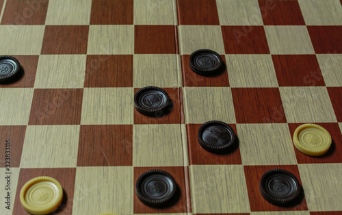Checkers. Draught board. Direct conflict between white and brown pieces.