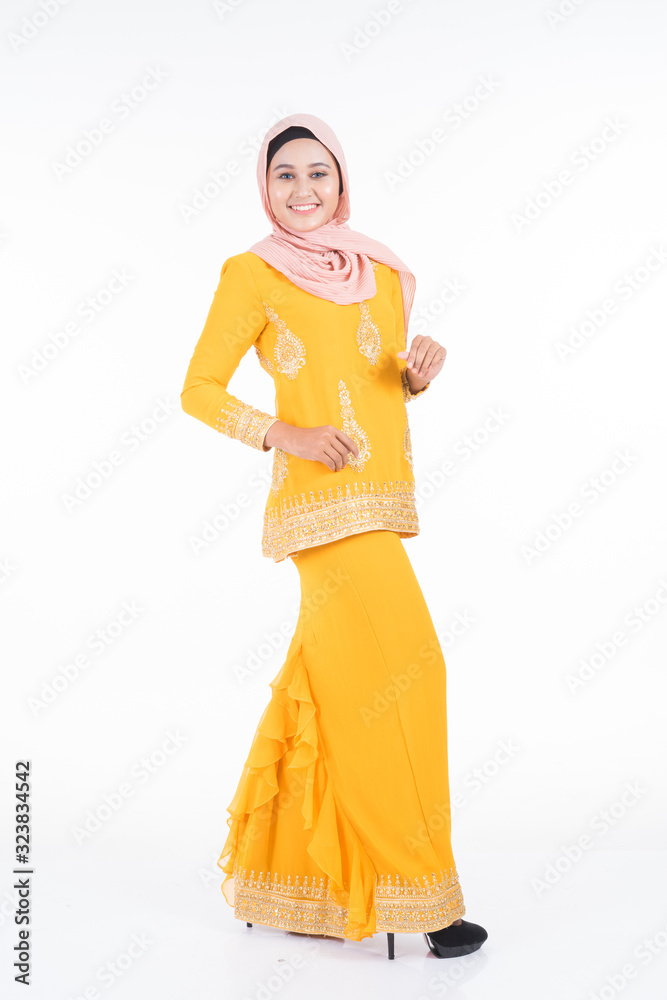 Beautiful female Muslim model in modern kurung and hijab, a modern lifestyle apparel for Muslim women isolated on white background. Beauty and hijab fashion concept. Full length portrait Beautiful female Muslim model in modern kurung and hijab, a modern lifestyle apparel for Muslim women isolated on white background. Beauty and hijab fashion concept. Full length portrait