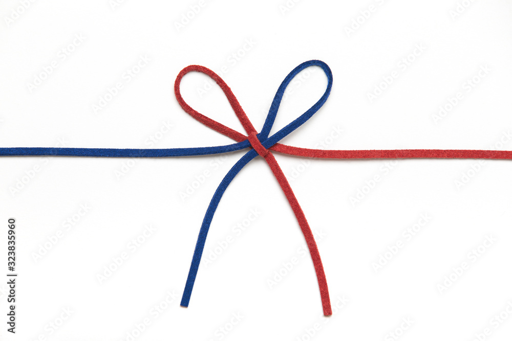 red and blue ribbon isolated on white background. two colors chamois string tied in a bow. red and blue ribbon isolated on white background. two colors chamois string tied in a bow.