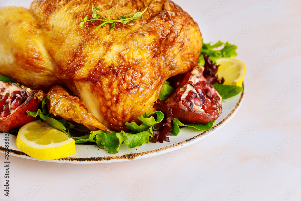Roasted turkey on plate with herbs and pomegranate.