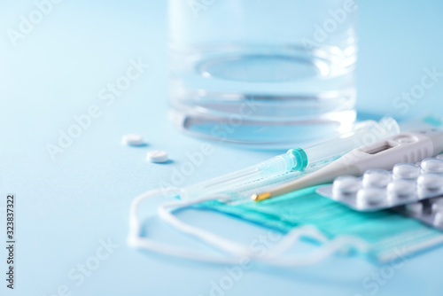 Set for flu treatment - pills, capsules, thermometer, protective surgical mask, syringe. Copy space. Banner. Viral attack. Bunch of drugs, cold flu treatment. Coronavirus Covid-19