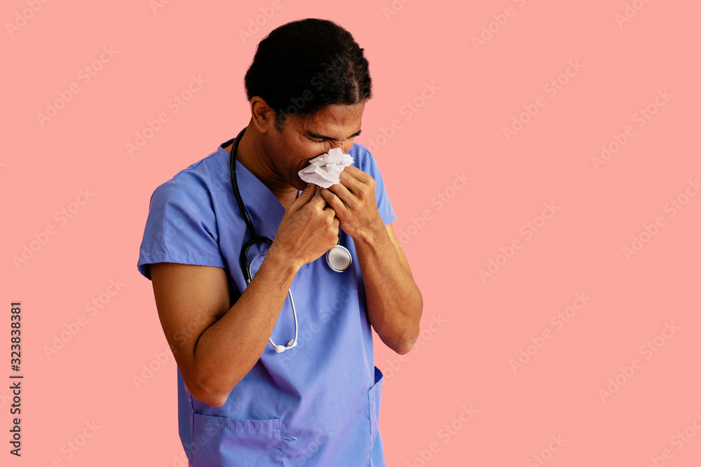Φωτογραφία Studio portrait of a sick male doctor or nurse wearing blue scrubs and stethosco