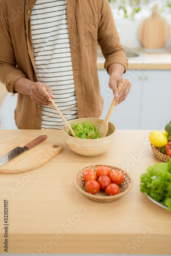 Young man preparing healthy vegetable salad