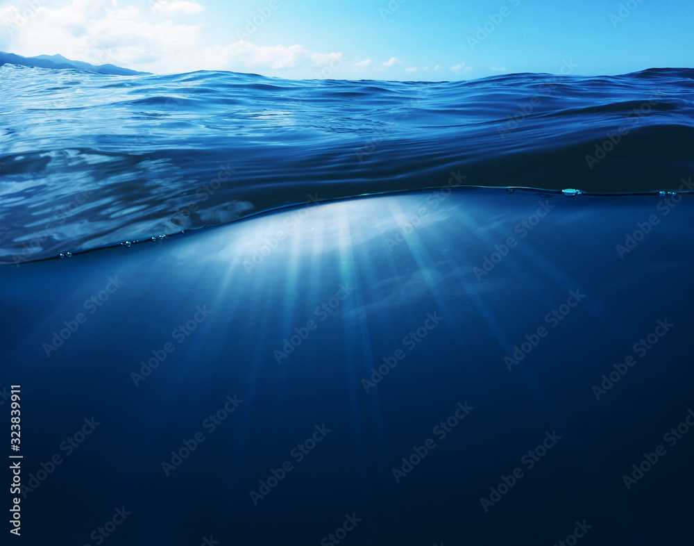 Fototapeta premium Underwater Deep Blue Sea and Sunlight Ray shining under the sea Summer background concept