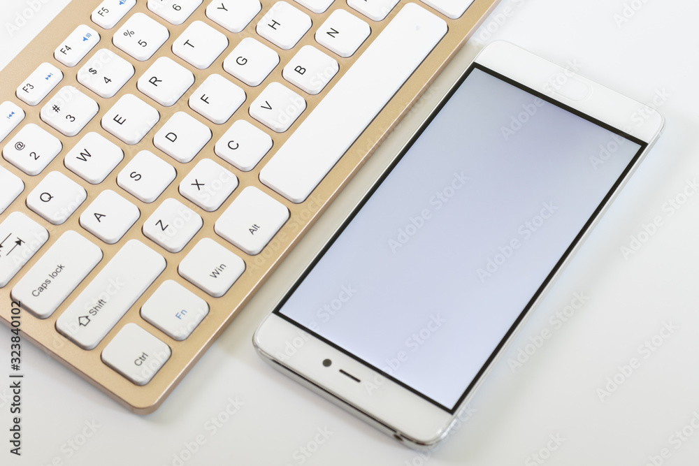 Phone on the keyboard, the phone has a white screen Phone on the keyboard, the phone has a white screen