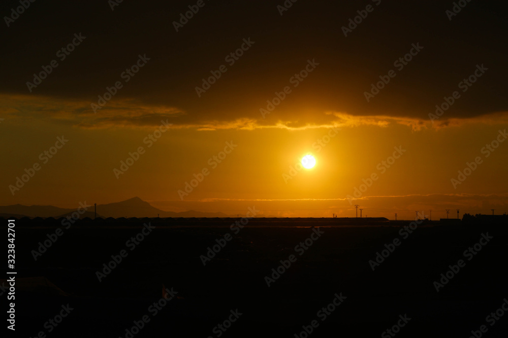 Orange sunset with clouds on the sky over the fields Orange sunset with clouds on the sky over the fields