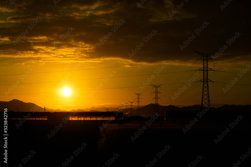 view to power line electric pylons and wires at the sunset