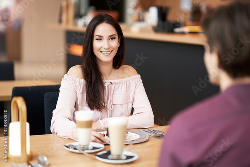 Young Couple Enjoying Coffee And Cake In Cafe
