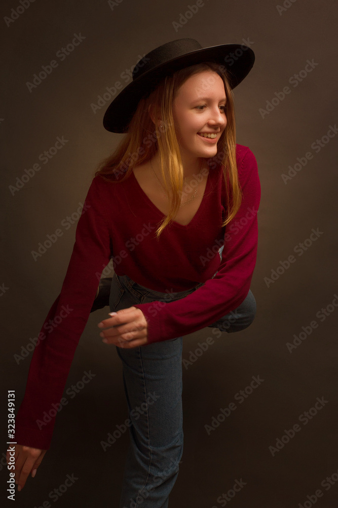 portrait of a girl in the Studio with painted blonde hair, in a red sweater and blue jeans. portrait of a girl in the Studio with painted blonde hair, in a red sweater and blue jeans.