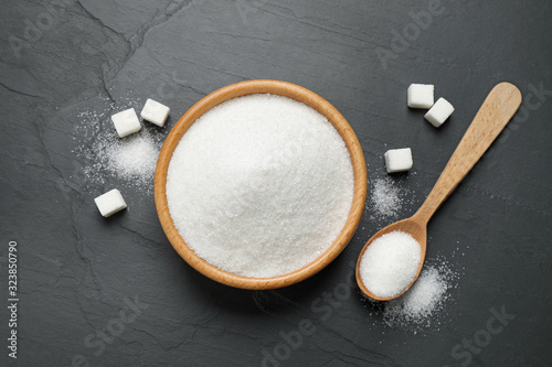 Fotografie Flat lay composition with granulated sugar on dark table