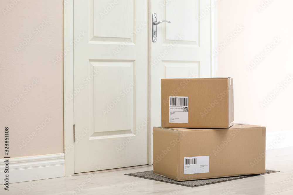 Fototapeta premium Parcels on rug near door. Delivery service
