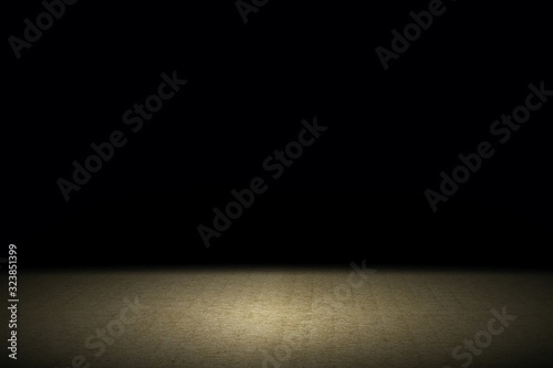 Light shining down on brown carpet floor in dark room with copy space, abstract background