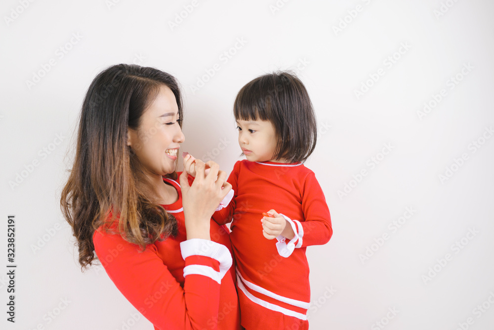 Portrait of young Asian mom and daughter over white background. Portrait of young Asian mom and daughter over white background.
