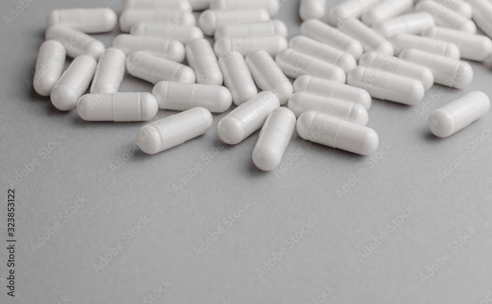 Scattered white oval pills for health. Concept of healthy lifestyle, vitamins taking. Scattered white oval pills for health. Concept of healthy lifestyle, vitamins taking.
