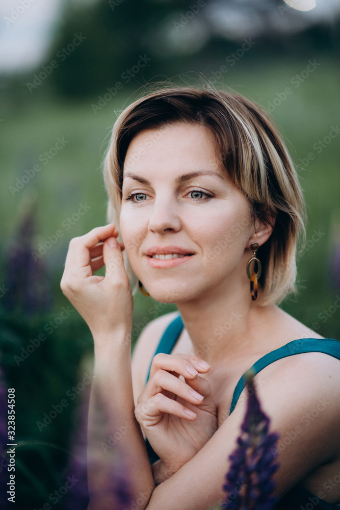 Beautiful romantic woman in a blue dress in a field of lupins flowers. Beautiful romantic woman in a blue dress in a field of lupins flowers.