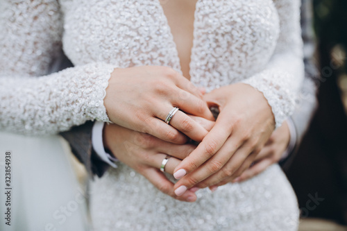 wedding guy and girl in a white dress holding hands on fingers wedding rings
