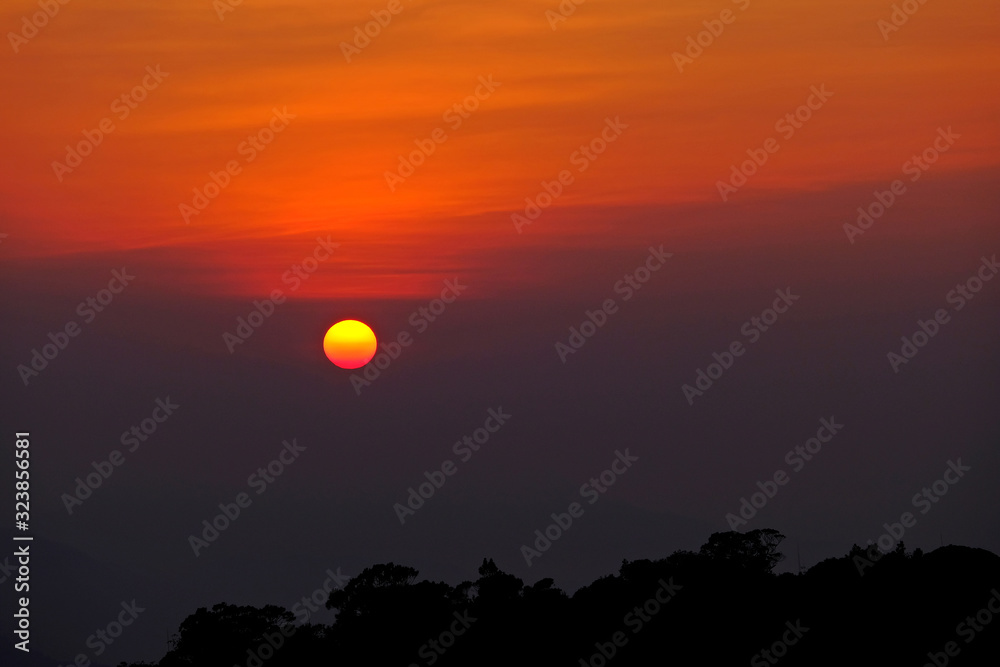 Gorgeous view of sunset with mountain range for background and silhouette of forest as foreground. Gorgeous view of sunset with mountain range for background and silhouette of forest as foreground.