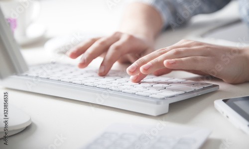 Hands typing on computer keyboard in office desk. photo